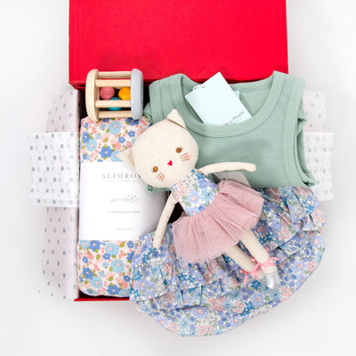 This pretty hamper for the warmer weather is the perfect combination of cute and practical. It features the sweetest selection of gifts for a new little miss including  ruffle floral bloomers and organic cotton tank top.  For swaddling a soft over-sized muslin wrap has been included and for play the adorable Odette Kitty Ballerina and wooden rattle toy will keep little one happy and entertained.  All items are beautifully presented in our chic, red, signature memory box. $165.00